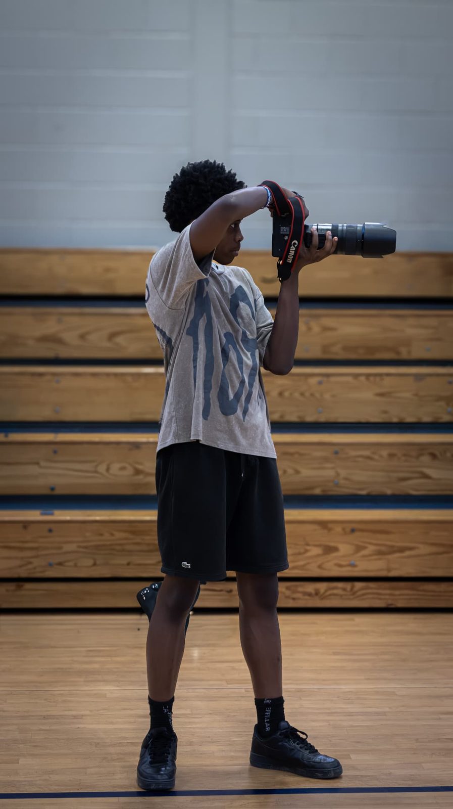A TAONI Media Assistant photographing basketball action